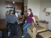 Juan Rubio, left, talks with his wife, Lindsey Rubio, while joined by their dog, Ruby, at Candlewood Suites near the Portland International Airport after getting out of the hospital on Dec. 13. He spent six weeks in the hospital after he was injured on the job at a Clark County dairy farm.