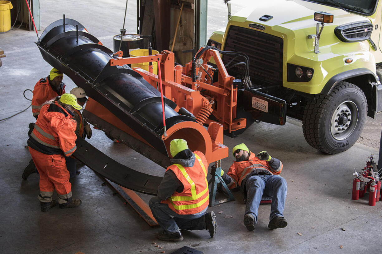 Washington State Department of Transportation crews help prepare a snowplow for upcoming winter conditions Wednesday afternoon at their Vancouver maintenance facility.