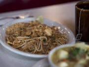 Pad thai with chicken, left, and chicken yellow curry are served at Ginger Pop in Vancouver.