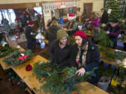 Camille Shelton gives her opinion to her mother, Angelene Shelton, as they assemble wreaths Sunday afternoon during a free wreath-making event at the Venersborg community center in the Battle Ground area. The Ridgefield women say the event is a family tradition.