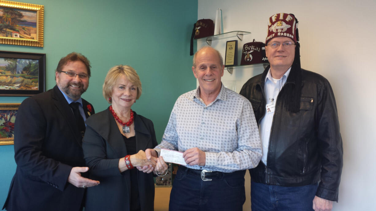 Portland: Dale Vrsalovich, from left, Art Liss and Ray Zimmerman from the Afifi Shriners Vancouver Gateway Shrine Club present a $2,500 check to Kathy Park, director of Donor Development for the Portland Shriners Children&#039;s Hospital.