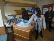 Linda Nguyen, center, and her fiance, Sonny Mouy, look over the CuddleCot at Legacy Salmon Creek Medical Center on Monday morning. The medical device gives parents of stillborns more time with their baby. Nguyen and Mouy raised money to buy it after their son, Connor Nguyen Mouy, was stillborn last year.