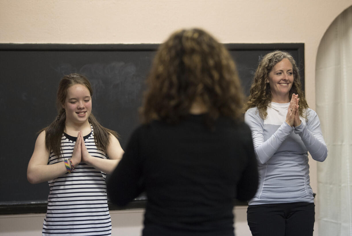 Aderyn McLean, left, teaches yoga alongside her mom, Kelly McLean, at the Vancouver Elite Gymnastics Academy in Camas. The 11-year-old taught classmates at recess to earn certification from Portland-based school Yoga Calm.