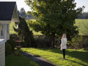 Kelly Smith is pictured in the backyard of her Ridgefield home as the fields of a neighboring farm are seen in the background.