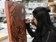 Columbia River High School art student Kimzaira Sotaridona, 16, finishes the detail work on her artwork Dec. 13.