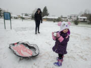 Jasmine Short, 2, of Vancouver joins her 13-year-old sister, Destinee, as they enjoy a snow day at Sorenson Park on Thursday afternoon.