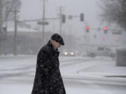 Kevin Weaver of Vancouver bundles up in a black coat and hat while trying to stay warm in the snow in downtown Vancouver on Thursday afternoon, Dec. 8, 2016.