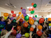 Balloons drop on children who had counted down to noon Saturday at the Noon Year&#039;s Celebration at the Three Creeks Community Library in Salmon Creek.