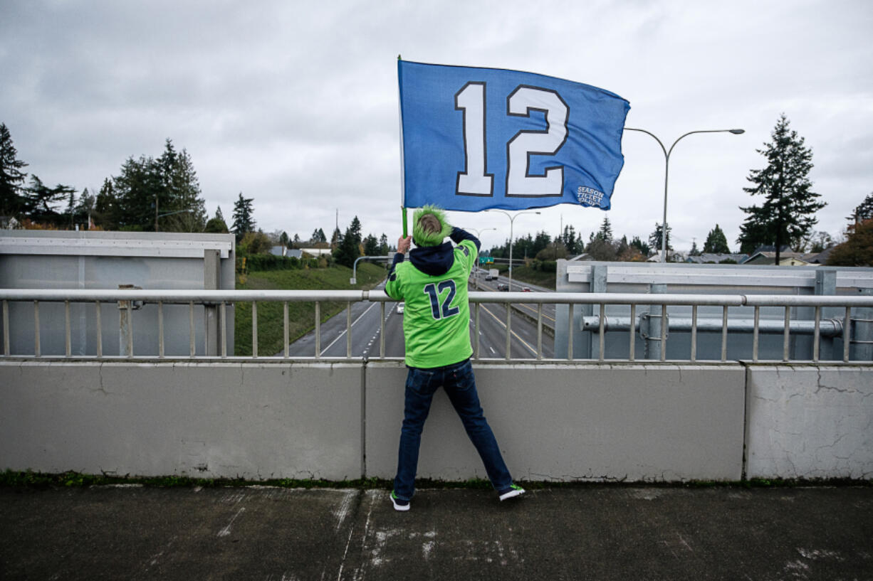 Seattle Seahawks fan Mike Meherin waves a 12 flag on the 29th Street overpass of Interstate 5 in Vancouver on Nov. 27 before the afternoon football game. Meherin, who lives in Vancouver&#039;s Uptown Village, has been waving the flag from the overpass since 2012.