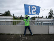 Seattle Seahawks fan Mike Meherin waves a 12 flag on the 29th Street overpass of Interstate 5 in Vancouver on Nov. 27 before the afternoon football game. Meherin, who lives in Vancouver&#039;s Uptown Village, has been waving the flag from the overpass since 2012.