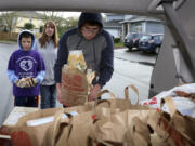 Thirteen-year-old Zachary Borghello, from left, Kim Prather and Josh Prather, 14, load donated food into the Autism Serves Kids Care Club&#039;s minivan in Saturday&#039;s Walk &amp; Knock.