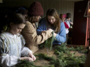 Fort volunteer Margaret Kerby, 11, left, makes wreaths with Emily Winterham, middle, and Camille Shelton on Dec. 13, 2014, at the Christmas at the Fort event.