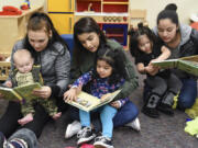 From left to right, Stephanie Watson and her son, Zaine Post; Vanessa Toscano and her daughter, Jaylah Castro; and Fanny Lopez and her daughter, Alexandra Lopez, read together Dec. 13 during story time in the GRADS program at Evergreen High School. A recent state study found that for every dollar invested in the program, students benefit by three times as much.