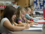 Kindergartners Cheyenne Hill, 6, left, and Corey Henderson, 5, look over their schoolwork at Tukes Valley Primary School on Nov. 30. Battle Ground Public Schools expanded full-day kindergarten at all of its campuses this year.