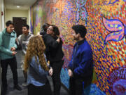 Fort Vancouver High School teacher and MEChA advisor Bethany Rivard, center, hugs MEChA mentor Rodolfo Serna in front of the student-painted mural unveiled Friday at the Vancouver Police Department&#039;s West Precinct. The mural represents themes such as identity, cultural pride and social justice.