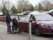 John Cummings of Vancouver pushes Linda Stithem in a wheelchair from her radiation appointment Dec. 14 at Legacy Salmon Creek Medical Center to his awaiting car. Cummings provides Stithem with rides to and from her daily appointments through the American Cancer Society&#039;s Road to Recovery program.