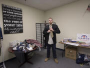 Veteran Chris Stephens knots a tie while trying on a suit Friday at the Farmers Insurance district office.