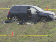 A vehicle in a field is surrounded by crime-scene tape Sunday as detectives investigate the shooting of a suspected prowler by a Clark County Sheriff's Office deputy in a rural area east of Ridgefield. The deputy responded to the area Sunday morning after a homeowner called 911 to report an unwanted man on his property.