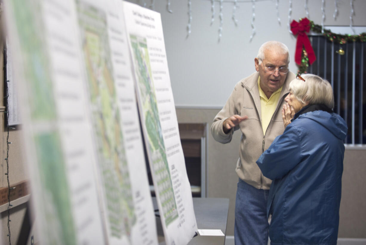 Gerald Jones and his neighbor Barbara Staudacher look at plans for a new Clark County campus in east Ridgefield. The college presented the final master plan for the new campus Monday at the Ridgefield Community Center.