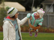 Sarah Bunn and her daughter Parker, 2, enjoy the swings Saturday as the Felida Neighborhood Association officially opens Sorenson Park.