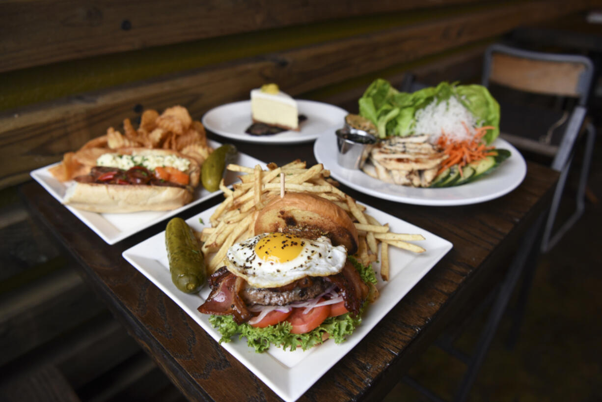 The Old Town Burger, center, is pictured next to the Millie May sandwich, from left, lemon cheesecake and lettuce wraps with chicken at Barrel Mountain Brewing in Battle Ground.