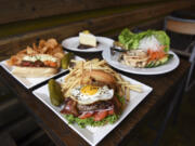 The Old Town Burger, center, is pictured next to the Millie May sandwich, from left, lemon cheesecake and lettuce wraps with chicken at Barrel Mountain Brewing in Battle Ground.