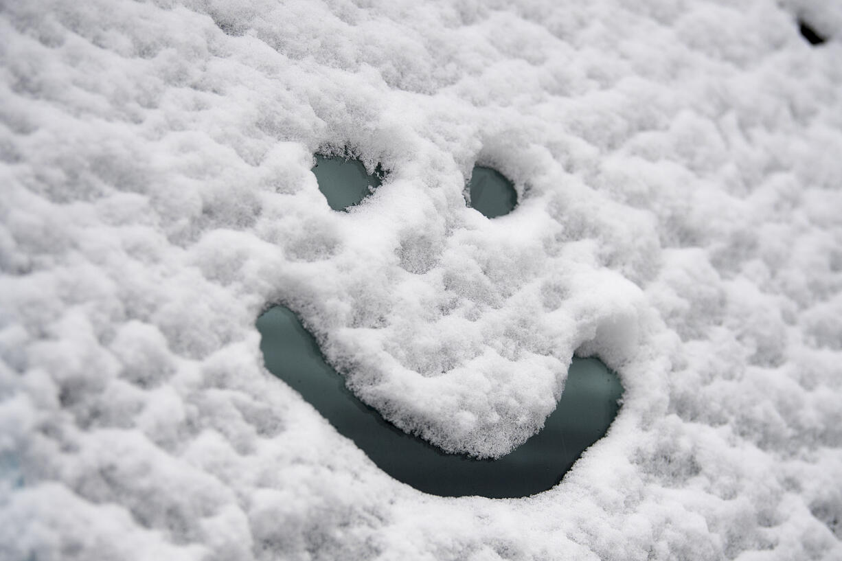 A friendly face is drawn into a snow-covered truck near Lincoln Elementary School on Dec. 15.