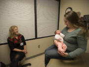 Dr. Heather Weldon, from left, visits with baby Cora Baker, 3 weeks, and her mom, Amber Baker, on Wednesday afternoon at PeaceHealth Southwest Medical Center. Amber Baker delivered Cora via cesarean section but was still able to have skin-to-skin contact with her daughter immediately after the surgery.