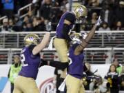 Washington tight end Darrell Daniels, right, celebrates his touchdown catch with teammates Aaron Fuller, center, and Jake Eldrenkamp during the first half of the Pac-12 Conference championship game against Colorado in Santa Clara, Calif. Alabama will play Washington and Ohio State is set to face Clemson in the College Football Playoff semifinals, announced Sunday, Dec. 4, 2016.