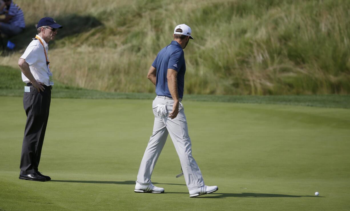 Dustin Johnson, right, talks to a rules official on the fifth green during the final round of the U.S. Open golf championship on June 19, 2016, at Oakmont Country Club, in Oakmont, Pa. The USGA and R&amp;A have adopted a local rule for 2017 that will waive the one-shot penalty for players when their golf balls or ball markers accidentally move on the putting green.