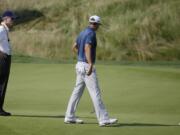 Dustin Johnson, right, talks to a rules official on the fifth green during the final round of the U.S. Open golf championship on June 19, 2016, at Oakmont Country Club, in Oakmont, Pa. The USGA and R&amp;A have adopted a local rule for 2017 that will waive the one-shot penalty for players when their golf balls or ball markers accidentally move on the putting green.