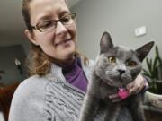 In this Tuesday, Dec. 13, 2016 photo, Robin Harris holds the cat, Cleo, in Mission, Ore., that she found in her hay barn over the weekend. The kitten ran off after her family was involved in a car crash near Harris's house while moving from Utah to Washington and was presumed dead until Harris called the family with the number on the cat's name tag. (E.J.