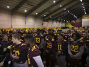 University of Minnesota wide receiver Drew Wolitarsky, flanked by quarterback Mitch Leidner, obscured behind Wolitarsky, and tight end Duke Anyanwu gestures as he stands in front of other team members while talking to reporters in the Nagurski Football Complex in Minneapolis, Minn., Thursday night, Dec. 15, 2016.  The players delivered a defiant rebuke of the university's decision to suspend 10 of their teammates, saying they would not participate in any football activities until the school president and athletic director apologized and revoked the suspensions. If that meant they don't play in the upcoming Holiday Bowl against Washington State, they appeared poised to stand firm.