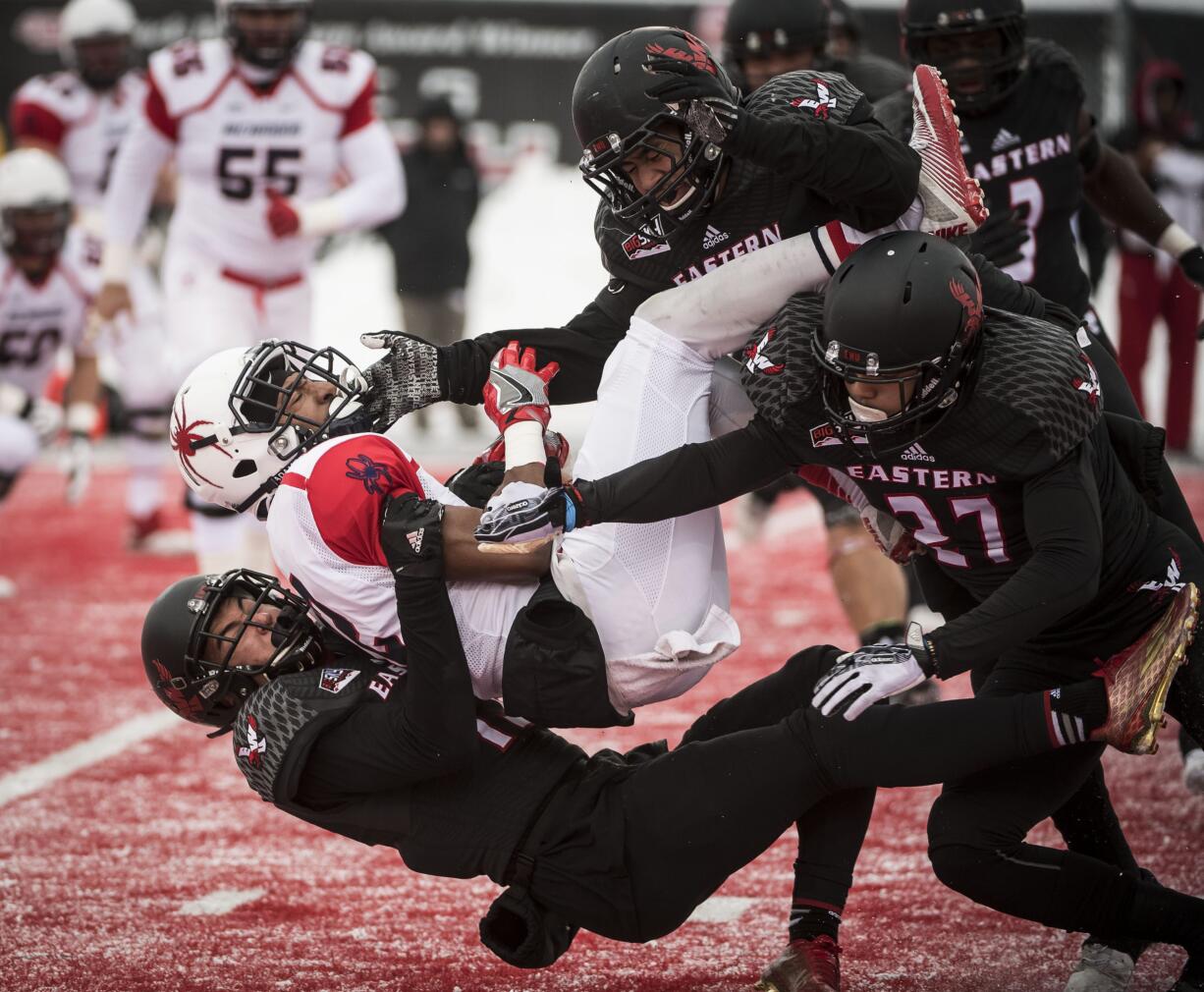 Richmond wide receiver Brian Brown (12) is tackled by Eastern Washington defensive back Mitch Fettig, bottom, defensive back Victor Gamboa (27), and linebacker Miquiyah Zamora, top, during the first half of a second round FCS playoff NCAA college football game at Roos Field, Saturday Dec. 10, 2016, in Cheney, Wash.