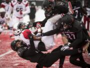 Richmond wide receiver Brian Brown (12) is tackled by Eastern Washington defensive back Mitch Fettig, bottom, defensive back Victor Gamboa (27), and linebacker Miquiyah Zamora, top, during the first half of a second round FCS playoff NCAA college football game at Roos Field, Saturday Dec. 10, 2016, in Cheney, Wash.