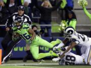 Seattle Seahawks wide receiver Tyler Lockett (16) scores a touchdown ahead of Los Angeles Rams cornerback Trumaine Johnson (22) after a reception in the second half of an NFL football game, Thursday, Dec. 15, 2016, in Seattle.