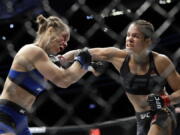 Amanda Nunes, right, connects with Ronda Rousey in the first round of their women&#039;s bantamweight championship mixed martial arts bout at UFC 207, Friday, Dec. 30, 2016, in Las Vegas. Nunes won the fight after it was stopped in the first round.