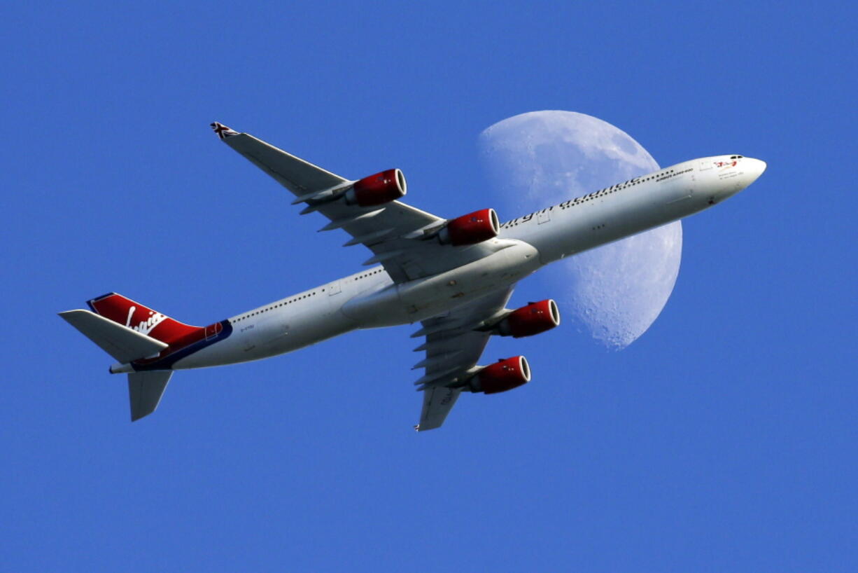 A Virgin Atlantic passenger plane crosses a waxing gibbous moon on its way to the Los Angeles International Airport in 2015. On Tuesday, Alaska Airlines said it has won government approval to buy rival Virgin America after agreeing to reduce its flight-selling partnership with American Airlines.