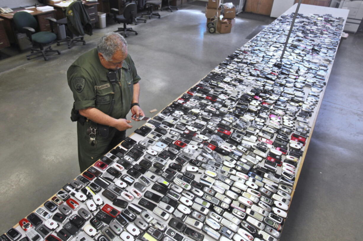 Correctional Officer Jose Sandoval inspects one of the more than 2,000 cellphones confiscated from inmates at California State Prison, Solano in Vacaville, Calif., in 2009. California is installing nearly 1,000 sophisticated metal detectors and scanners at its prisons in its latest attempt to thwart the smuggling of cellphones.