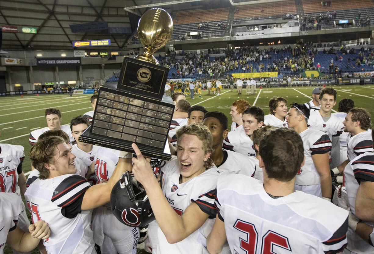 Camas team members celebrate with the trophy after they defeated  Richland in the 4A State Football Championship game Saturday, Dec. 3, 2016, in Tacoma.