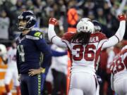 Seattle Seahawks kicker Steven Hauschka, left, and Arizona Cardinals free safety D.J. Swearinger (36) react after Hauschka missed a point after a touchdown in the fourth quarter of an NFL football game, Saturday, Dec. 24, 2016, in Seattle.  (AP Photo/Ted S.