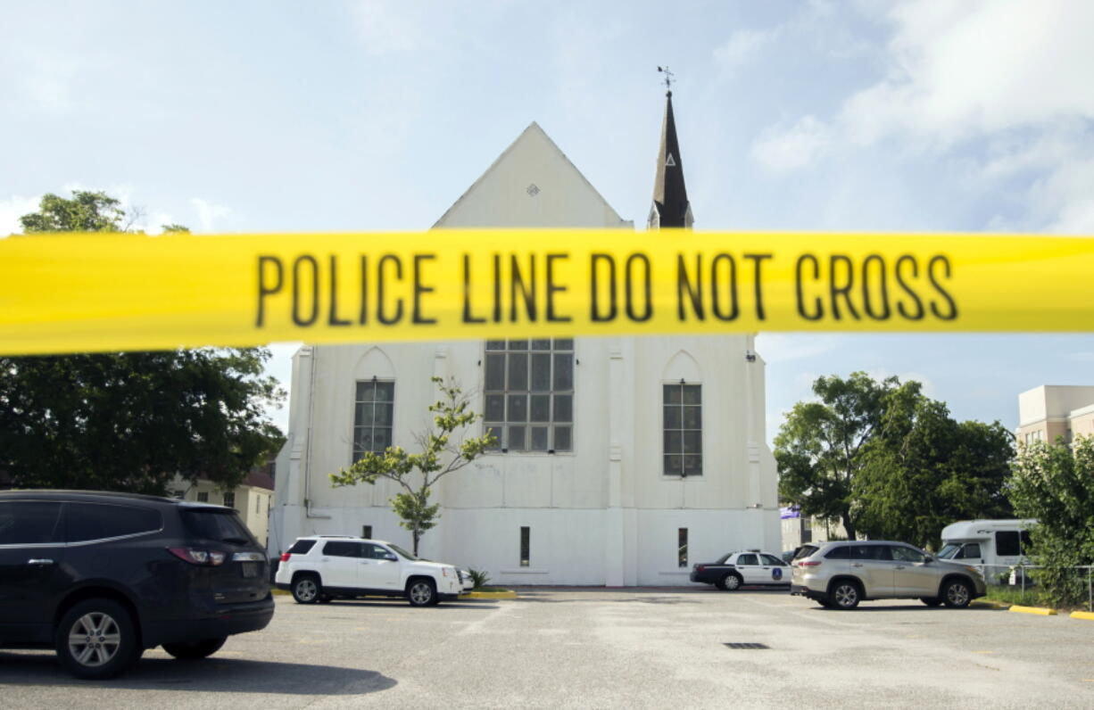 Police tape surrounds the parking lot behind the AME Emanuel Church as FBI forensic experts work the crime scene, in Charleston, S.C., on June 19, 2015. (AP Photo/Stephen B.