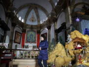 A woman walks past a decoration displaying a baby Jesus doll part of a Nativity scene at the Nantang Catholic Church in Beijing on Wednesday. China&#039;s head of religious affairs said that Beijing is willing to have constructive dialogue with the Vatican but stressed that Catholics should &quot;hold up high the flag of patriotism&quot; and adapt Catholicism to Chinese society.