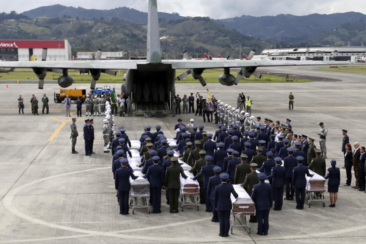 Air force members and police accompany the caskets containing the remains of Brazilian plane crash victims, at the military airbase in Rio Negro, Colombia, Friday, Dec. 2, 2016. The bodies of the Brazilian victims are being repatriated to Chapeco, the hometown of the Brazilian soccer team whose members were on the doomed LaMia flight along with a group of journalists, headed to the Copa Sudamericana finals.