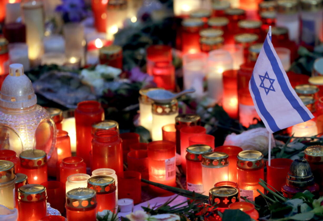 A small flag of Israel is pictured between candles and flowers after the reopening of the Christmas market at the Kaiser Wilhelm Memorial Church in Berlin, Germany, on Thursday, three days after a truck ran into the crowded market and killed several people.