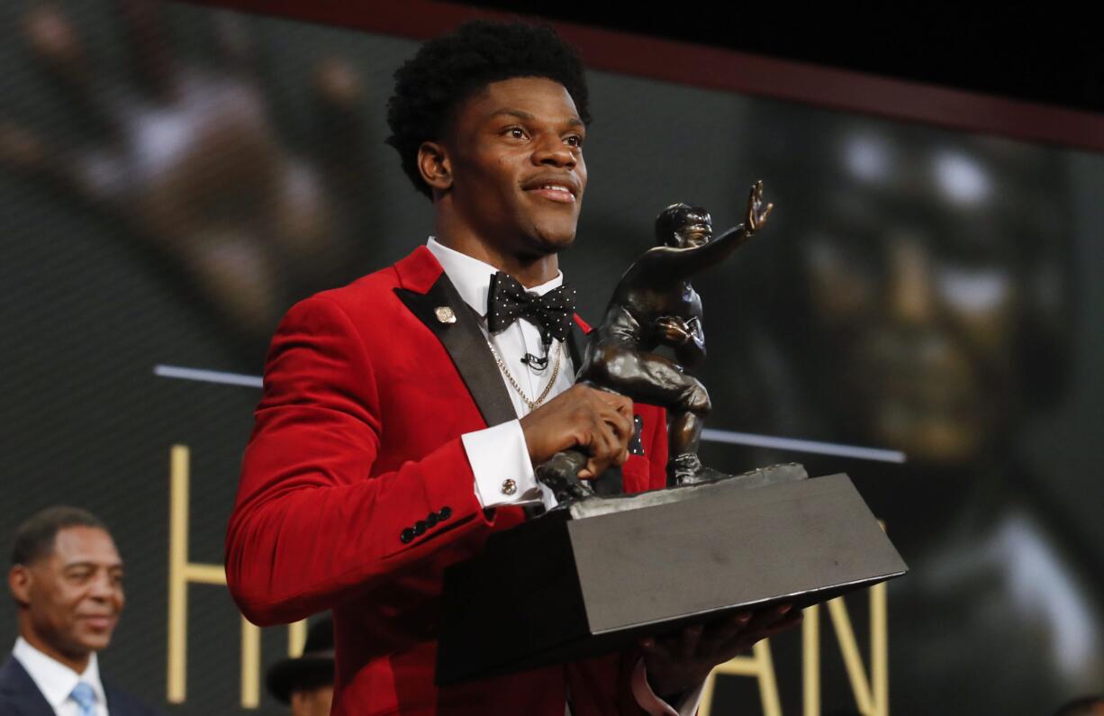 Louisville's Lamar Jackson holds up the Heisman Trophy after winning the Heisman Trophy award Saturday, Dec. 10, 2016, in New York.