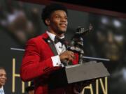 Louisville's Lamar Jackson holds up the Heisman Trophy after winning the Heisman Trophy award Saturday, Dec. 10, 2016, in New York.