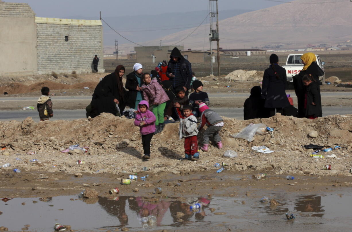 Displaced Iraqis, who fled fighting between Iraqi security forces and Islamic State militants, waiting at the gathering point to be taken for a camp for internally displaced people, in Bartella, around 19 miles (30 kilometers), from Mosul, Iraq, Saturday, Dec 31, 2016.