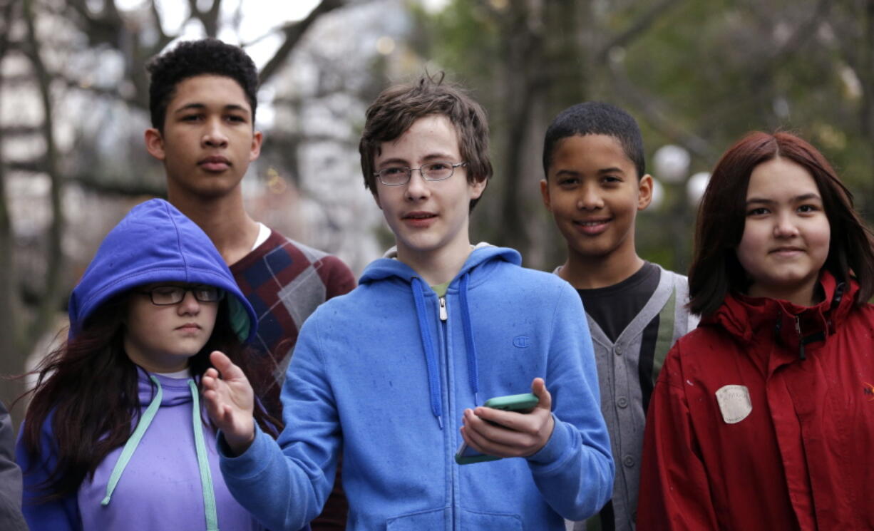 Petitioner Gabe Mandell, center, 14, addresses media members and supporters Nov. 22 in Seattle as he stands with other children asking a court to force state officials to adopt new rules to limit carbon emissions.