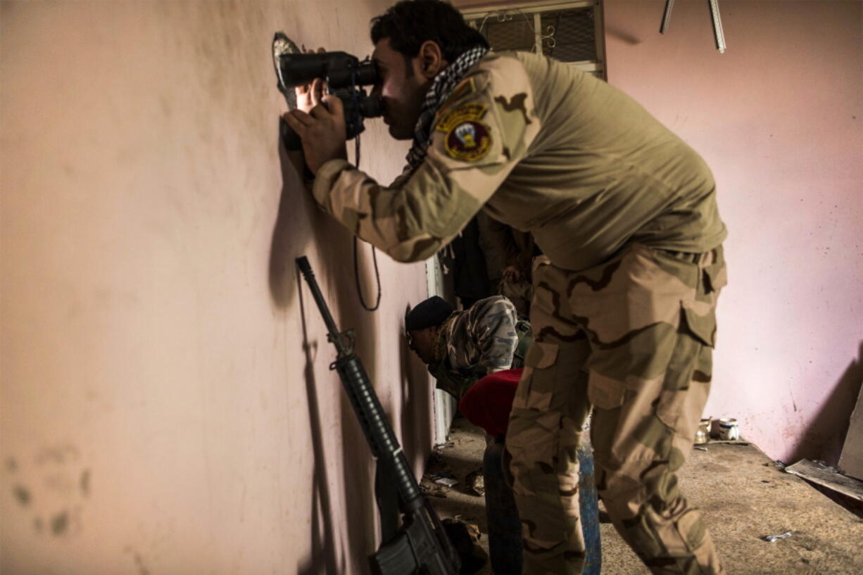 An Iraqi soldier from the 9th Division looks through a sniper hole Monday at the Al-Intisar district in Mosul, Iraq. Mosul, Iraq&#039;s second-largest city, is the last major Islamic State extremist urban bastion in the country. Iraqi troops have advanced cautiously to avoid civilian casualties.